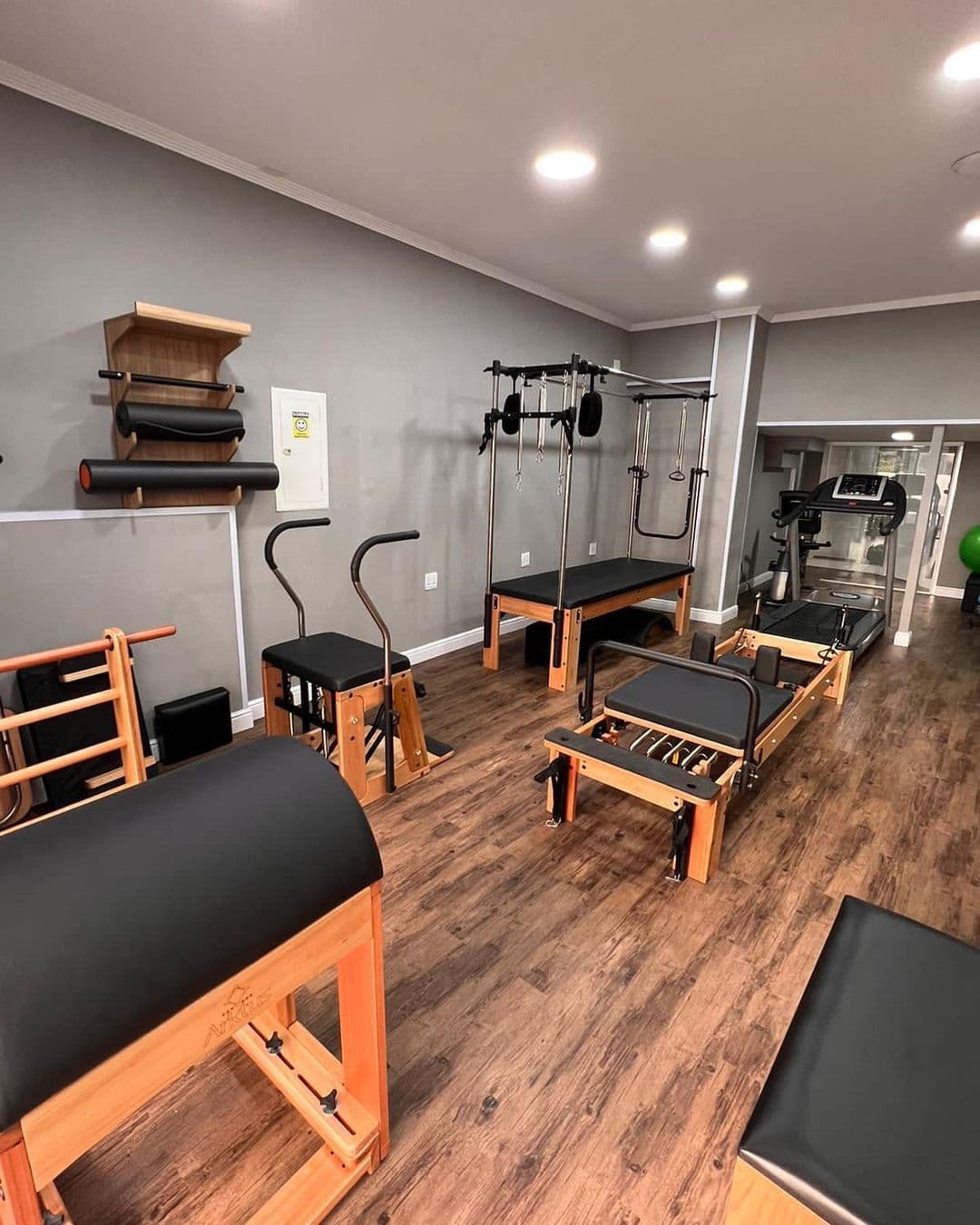 O estúdio de pilates da Ox: reformer, chair, barrel e cadillac sobre piso de madeira